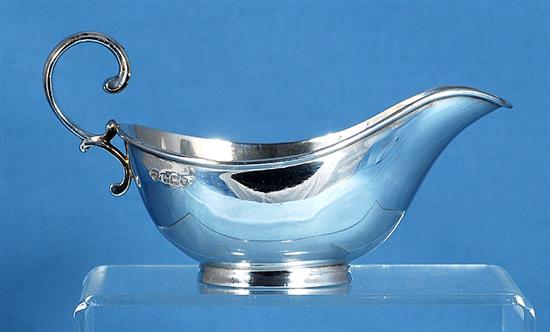 A 1930s silver asparagus draining dish with asparagus servers and sauce boat, by Goldsmiths & Silversmiths Co, tray length